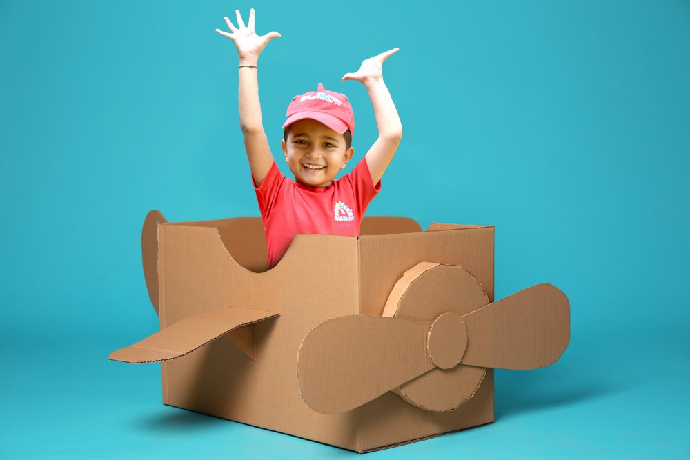 Joyful child in cardboard plane